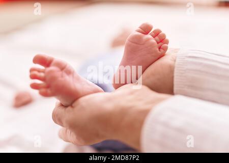 Mother and son lying on bed holding feet at bedroom Stock Photo