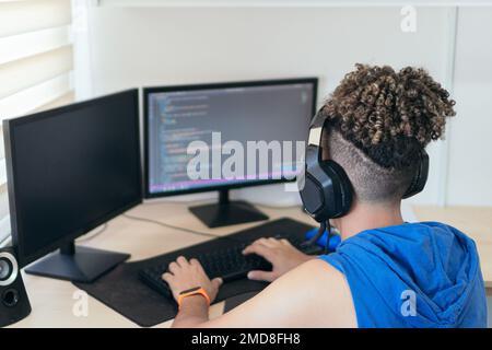 Software engineer sitting at desk and typing on computer keyboard while creating code while working at home. Stock Photo