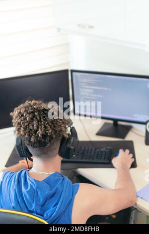 From above, software engineer sitting at desk and typing on computer keyboard while creating code during work at home. Stock Photo