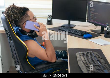 Man Talking On The Phone While Sitting At The Table At Home Stock Photo