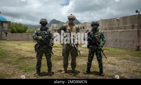 MARINE CORPS TRAINING AREA BELLOWS, Hawaii (July 14, 2022) Republic of Korea Marine Corps Master Sgt. Bugyun-Jung, left, team leader, Korean Marine Recon Team, U.S. Marine Corps Cpl. Juan D. Betances, middle, machine gunner, 3rd Battalion, 4th Marines, 1st Marine Division, and Indonesia-Korps Marinir Republik Indonesia Private First Class Rully Hidayat, pose for a photo before conducting simulated Military Operations in Urban Terrain (MOUT) during Rim of the Pacific (RIMPAC) 2022, July 14. Twenty-six nations, 38 ships, four submarines, more than 170 aircraft and 25,000 personnel are participat Stock Photo