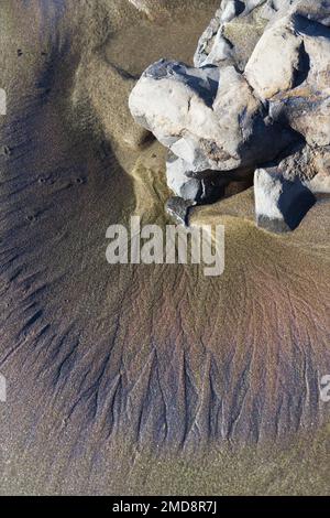 Patterns in sand after a winter storm and king tide, on the central coast of Oregon. Stock Photo