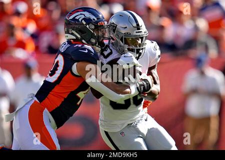 Las Vegas Raiders running back Jalen Richard is tackled by Denver Broncos  inside linebacker Justin Strnad, left, during the first half of an NFL  football game, Sunday, Oct. 17, 2021, in Denver. (