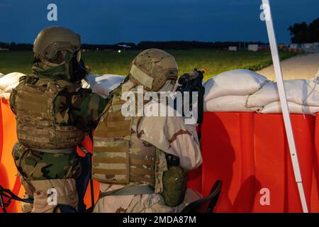 Members from the 512th and 436th security forces squadrons guard an entry control point during the Liberty Eagle Readiness Exercise at Dover Air Force Base, Delaware, July 14, 2022. Both squadrons demonstrated their ability to guard ECPs while wearing mission oriented protective posture gear at the simulated forward operating base, located on Dover AFB, July 11-15, 2022. The purpose of this exercise was to validate both wings' ability to generate, employ and sustain airpower across the world in a contested and degraded operational environment. Stock Photo