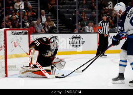 Winnipeg Jets center Pierre-Luc Dubois, top, puts Vancouver Canucks  defenseman Quinn Hughes (43) into the boards during second-period NHL  hockey game action in Vancouver, British Columbia, Sunday, Feb. 21, 2021.  (Jonathan Hayward/The