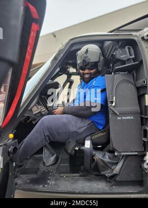 Trente Jones, a member of the University of Michigan football team enjoys participating in a static display of equipment including this UH-60 Blackhawk helicopter, at the 3rd Battalion, 238th Aviation Regiment, Grand Ledge, Michigan, July 15, 2022. The Michigan Army National Guard partnered with the University of Michigan football team under the Name, Image, or Likeness law that was passed,  contracting with players with high social media followings and using their influences help us reach recruiters' target market. Stock Photo