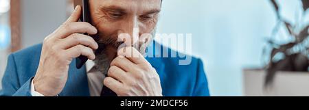 Close up of pensive bearded man talking on smartphone Stock Photo