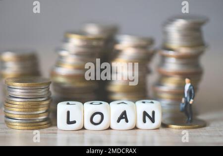 Loan business economy concept of money and finance on table, Loan business finance economy and business man standing on a coin on wooden table backgro Stock Photo