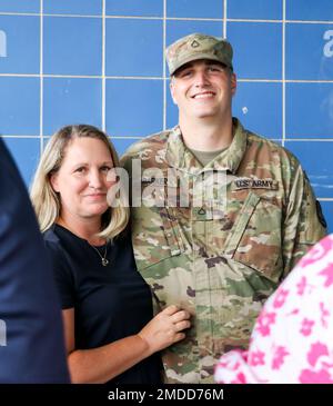 An Iowa Army National Guard Soldier assigned to the 209th Medical Company (Area Support) smiles with a loved one after the conclusion of a send-off ceremony at Clear Creek Amana High School in Tiffin, Iowa, on July 16, 2022. Senior leaders, family and friends gathered in the auditorium to honor the 80 Soldiers who are mobilizing to Poland in support of Operation Atlantic Resolve. They will be providing field hospital health service support as part of NATO’s Enhanced Forward Presence mission, which enables the U.S. to provide deterrence to adversaries while supporting our NATO partners. Stock Photo