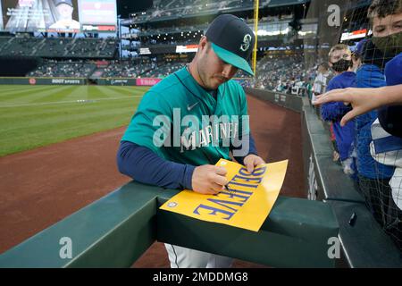 Seattle Mariners third baseman Ty France autographs a sign that reads  Believe before a baseball game against the Los Angeles Angels, Friday,  Oct. 1, 2021, in Seattle. Fans and the team have