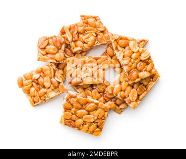 Sweet peanut brittle. Tasty peanuts in caramel isolated on the white background. Stock Photo