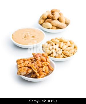 Sweet peanut brittle, peanuts and peanuts butter isolated on the white background. Stock Photo