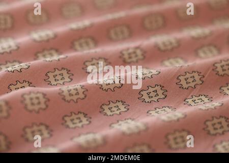 Wavy pink and white fabric with abstract ornament as background. Stock Photo