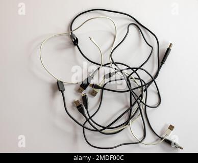 Used charging cables tangled on white isolated background Stock Photo