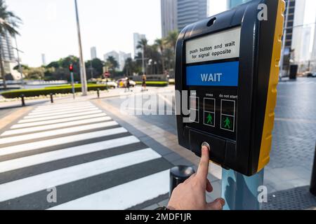 Close up of hand pressing the button on pedestrian crossing Stock Photo