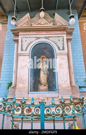 One of the many small, homemade Catholic, Christian wall, street shrines found in every neighborhood. This shrine is of blue tile with a statue, icon Stock Photo