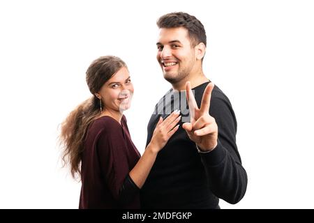 Cute cheerful man and woman couple wearing casual fall clothing smiling with boyfriend making peace or victory sign isolated on white background Stock Photo