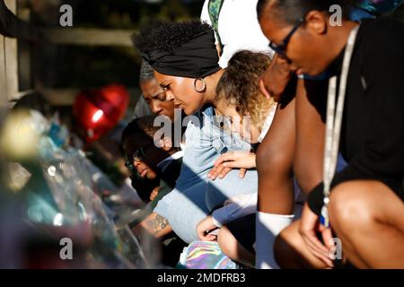 A group of women and children look at floral tributes for murdered 28-year-old teacher Sabina Nessa in Kidbrooke in south-east London, Friday, Sept. 24, 2021. Nessa’s killing has renewed concerns that women are not safe on the city’s streets, and a vigil is due to be held in her memory on Friday. Late Thursday police said they had arrested a man in a nearby area of London on suspicion of murder. He has not been charged, and his name was not released. (AP Photo/David Cliff)