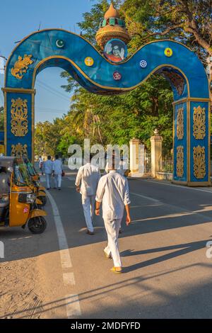 Puttaparthi, Andra Pradesh, India - January 18.2023: Jung Indian man in white closes walking along the road to the Sai Baba Ashram Stock Photo