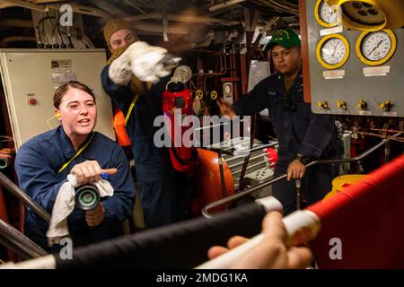 PHILIPPINE SEA (July 23, 2022) Electrician’s Mate 2nd Class Kaitlyn Green, left, and Gas Turbine Systems Technician (Mechanical) 3rd Class Colton Sims, from Dayton, Ohio, fight a simulated fire in the main engine room aboard Ticonderoga-class guided-missile cruiser USS Chancellorsville (CG 62). Chancellorsville is forward-deployed to the U.S. 7th Fleet in support of security and stability in the Indo-Pacific and is assigned to Commander, Task Force 70, a combat-ready force that protects and defends the collective maritime interest of its allies and partners in the region. Stock Photo