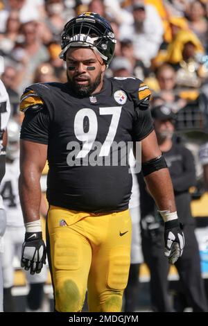 Pittsburgh Steelers defensive tackle Cameron Heyward (97) carries a flag  with Franco Harris number 32 on to the field before the start of the game  against the Las Vegas Raiders at Acrisure