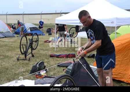 U.S. Air Force Capt. Aaron Bigio, a military nurse for the 349th Aeromedical Staging Squadron, sets up his tent at the 185th Air Refueling Wing at Sioux City, Iowa, July 23, 2022. Bigio is a member of the Air Force Cycling Team, which is riding in the 2022 Register’s Annual Great Bicycle Ride Across Iowa. Stock Photo