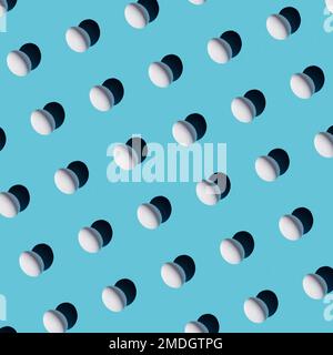 Chicken white eggs pattern on blue background. Festive Easter background from eggs Stock Photo
