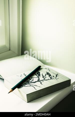 Sketch book and pencils on a windowsill Stock Photo - Alamy