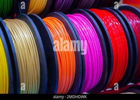 Many multi-colored spools of thread of filament for printing 3d printer. Material coils for printing 3D printer. Spools of 3D printing motley different colors filament. ABS wire plastic for 3d printer Stock Photo