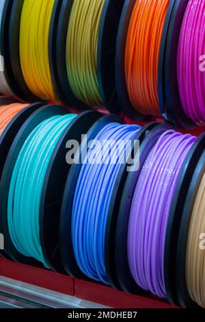 Many multi-colored spools of thread of filament for printing 3d printer. Material coils for printing 3D printer. Spools of 3D printing motley different colors filament. ABS wire plastic for 3d printer Stock Photo