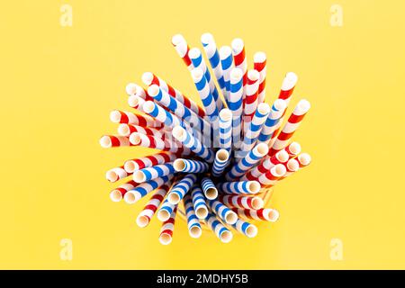 Paper straws for drinks on a yellow background, top view. Stock Photo