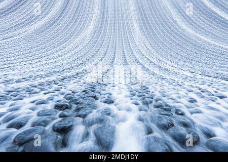 Small Waterfall and a Stream of Water in a Garden or Park. Abstract Summer Water Background. Artificial Stream In Summer Garden. Stock Photo