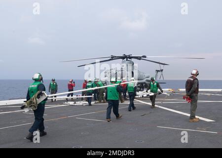 220725-N-XB010-1007 SOUTH CHINA SEA (July 25, 2022) Sailors assigned to the forward-deployed amphibious transport dock ship USS New Orleans’ (LPD 18) and Marines assigned to the 31st Marine Expeditionary Unit (MEU) approach a AH-1Z Cobra helicopter with a blade fold rack on New Orleans’ flight deck. New Orleans, part of the Tripoli Amphibious Ready Group, along with the 31st MEU, is operating in the U.S. 7th Fleet area of responsibility to enhance interoperability with allies and partners and serve as a ready response force to defend peace and stability in the Indo-Pacific region. Stock Photo