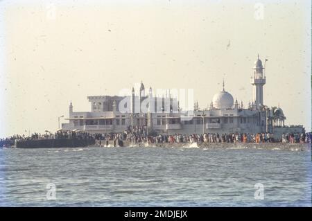 The Haji Ali Dargah is a mosque and dargah or the monument of Pir Haji Ali Shah Bukhari located on an islet off the coast of Worli in the southern Mumbai. An exquisite example of Indo-Islamic Architecture, associated with legends about doomed lovers, the dargah contains the tomb of Haji Ali Shah Bukhari. Stock Photo