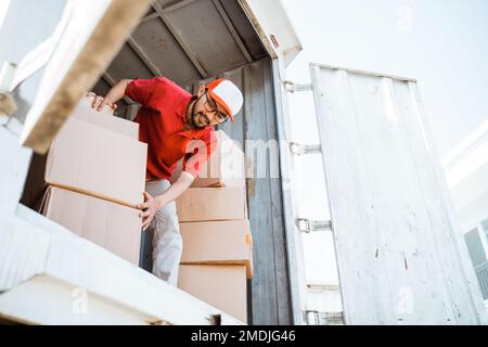 male employee working unloading boxes from containers Stock Photo