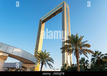 Dubai, UAE. November 25, 2022: Dubai Golden Frame best new landmark, which located in Zabeel Park. View on golden frame and palm tree Stock Photo