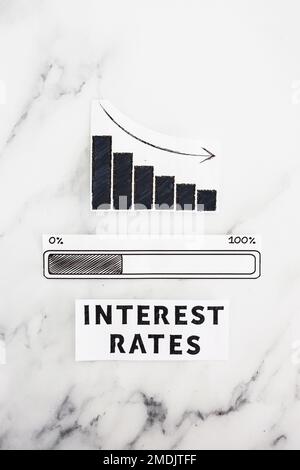interest rates going down, text with graph showing stats decreasing and progress bar loading underneath Stock Photo