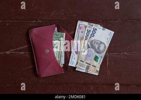 five hundred hryvnia bill lies in a red leather wallet on the table, Ukrainian hryvnia Stock Photo