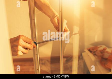 Assembling furniture at home.Closeup of man using screwdriver. Stock Photo
