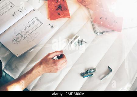 Man reading manual for self assembly furniture. Stock Photo