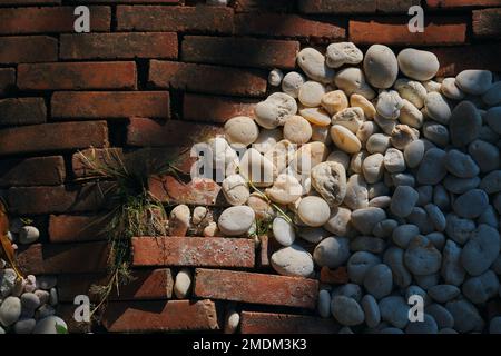 White pebbles and orange blicks on the floor Stock Photo