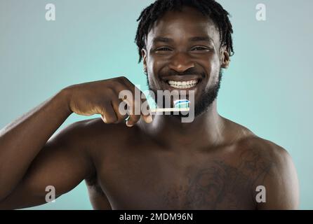 Black man, face and toothbrush with smile in portrait, teeth whitening and cleaning mouth isolated on studio background. Fresh breath, beauty and Stock Photo