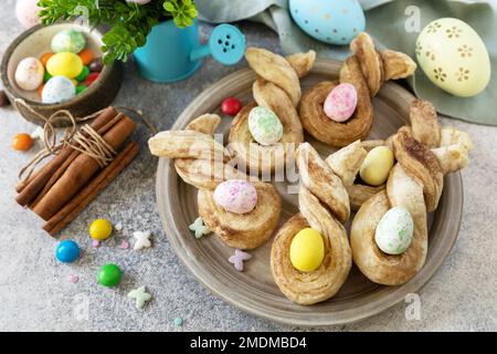 Easter rabbit-shaped buns puff pastry with  cinnamon on a stone tabletop. Easter bake idea. Stock Photo