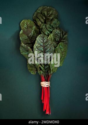 A vertical shot of red swiss chard on a dark grey surface flat lay Stock Photo