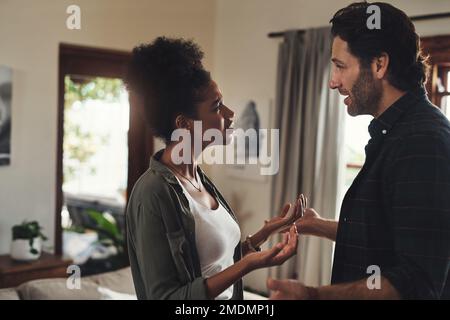 Were driving each other crazy. a young couple having an intense argument at home. Stock Photo