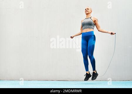 Making sure I have quick reflexes. Full length shot of an attractive young athlete using a skipping rope during an outdoor training session. Stock Photo