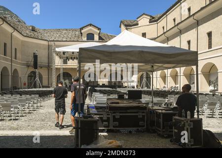 A group of technicians prepares a musical concert in the inner courtyard of Fort Bard in summer, Aosta, Aosta Valley, Italy Stock Photo