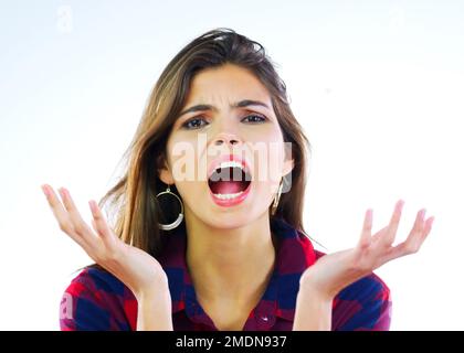 I need answers. Portrait of a young woman looking displeased against a white background. Stock Photo