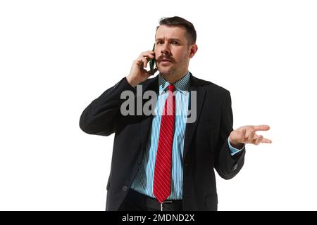 Businessman in a suit talking on phone with questioning face over white studio background. Misunderstanding. Concept of business, career, innovations Stock Photo