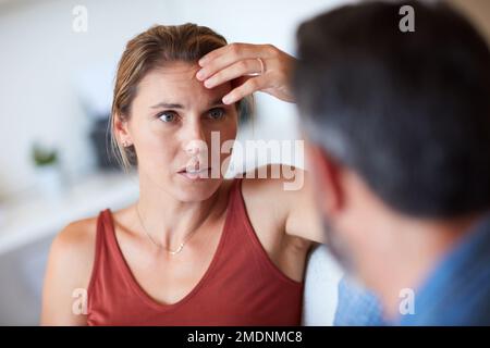 What are we going to do about this. an attractive young woman looking dismayed while having a serious conversation with her husband. Stock Photo